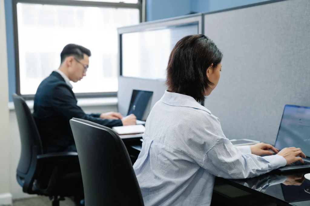 Two administration staff working at laptops in a Queensland office workspace